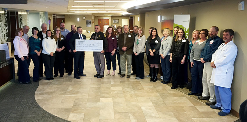 Hospital employees donate over $6,000 toward school doors.